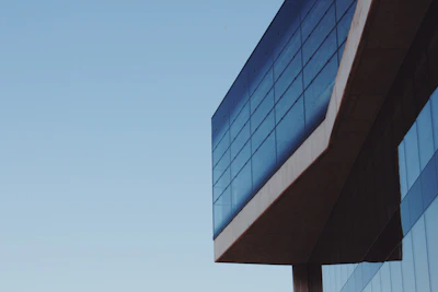 A modern building with clean lines and large glass windows reflecting the sky.