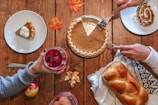person slicing pie beside bread