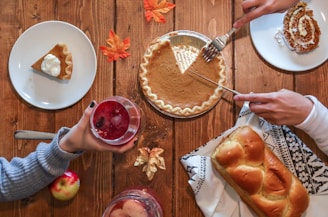 person slicing pie beside bread