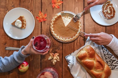 person slicing pie beside bread thanksgiving day zoom background