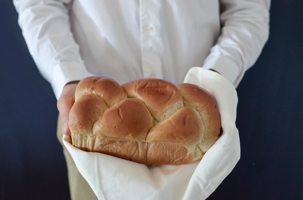 Person, die gebackenes Brot in der Hand hält