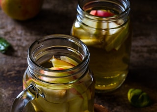 two drinking glasses filled with apple juice