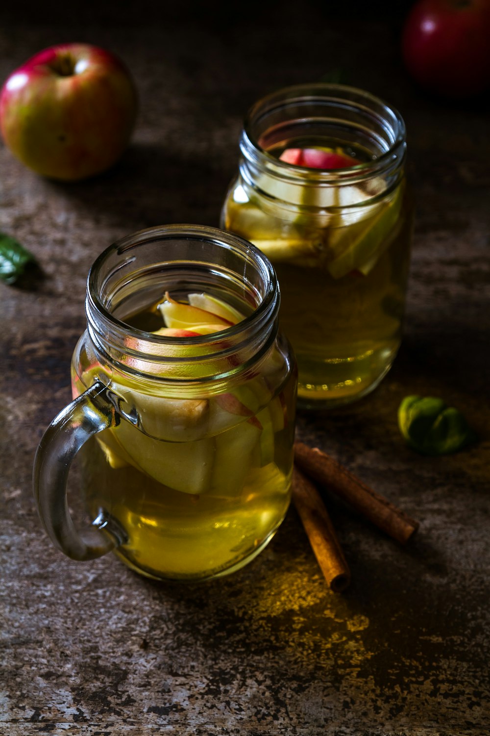 two drinking glasses filled with apple juice