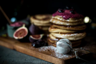 Brightly colored box of gluten-free pancake mix surrounded by fresh berries and leaves