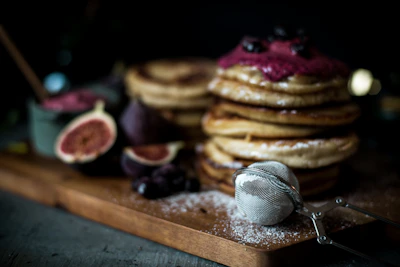 Brightly colored box of gluten-free pancake mix surrounded by fresh berries and leaves