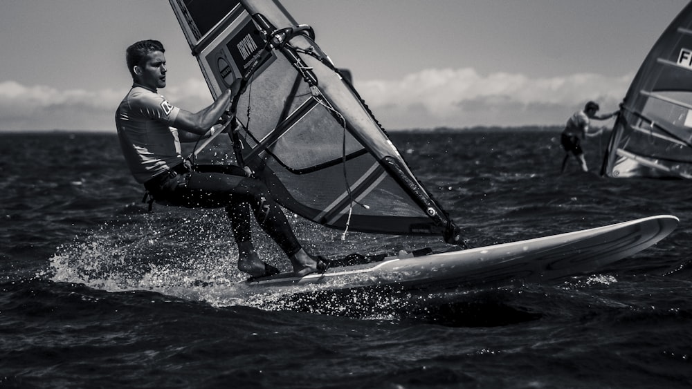 man riding surfboard with sail