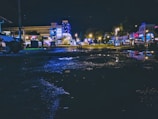 A minimalist shot of city lights reflected on wet pavement during a rainy night.