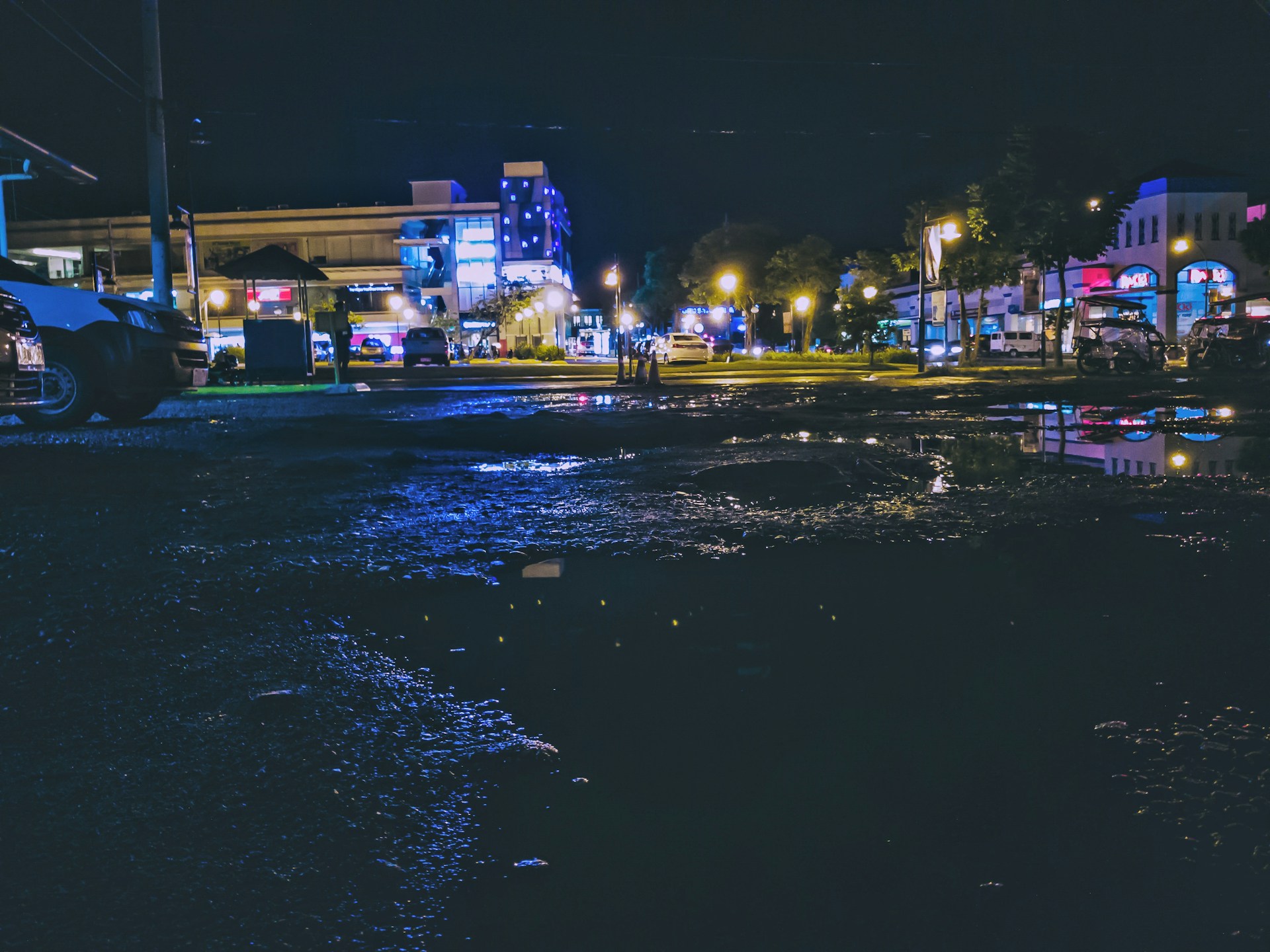 An urban night scene with vibrant city lights reflecting on wet pavement, full of dynamic energy.
