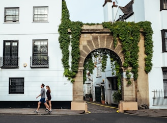 man and woman walking beside building