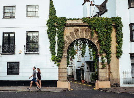 man and woman walking beside building