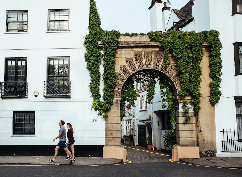 man and woman walking beside building