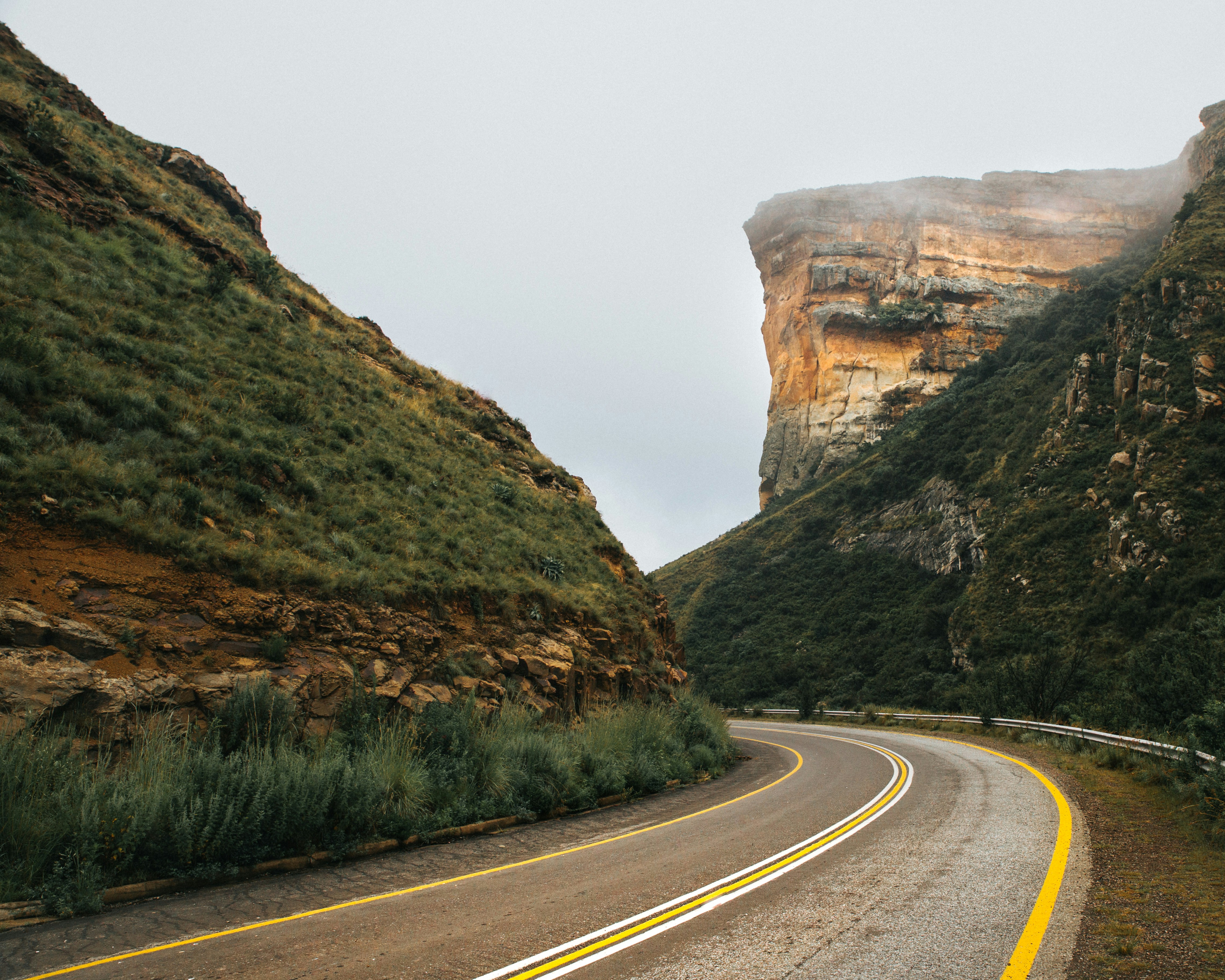 gray paved highway in between of mountain