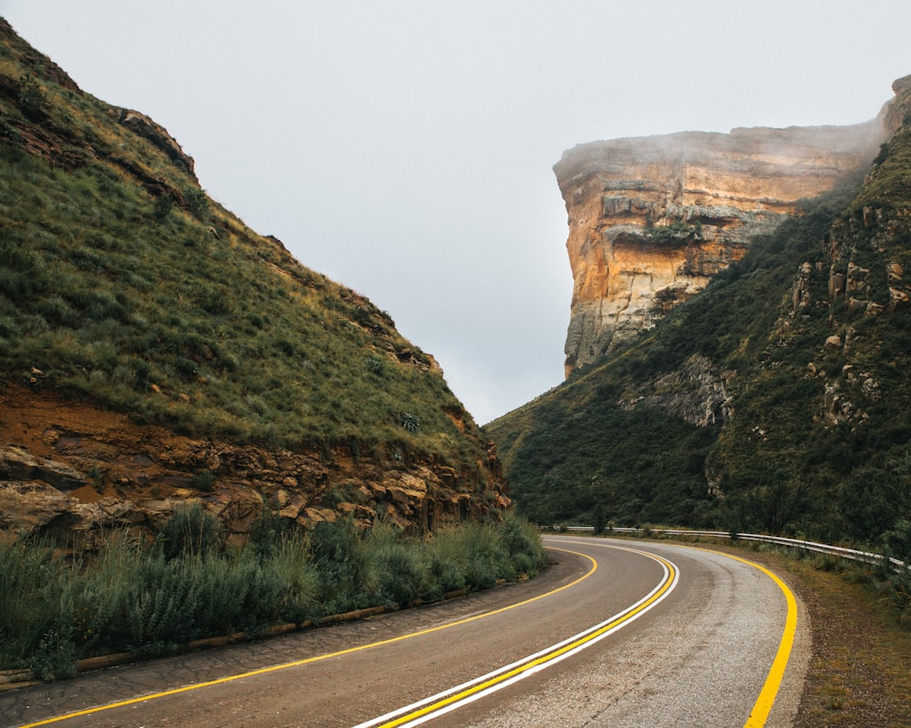 gray paved highway in between of mountain