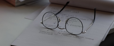 black framed eyeglasses on top of white printing paper