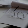 black framed eyeglasses on top of white printing paper