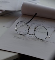 black framed eyeglasses on top of white printing paper