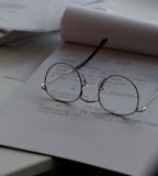 black framed eyeglasses on top of white printing paper