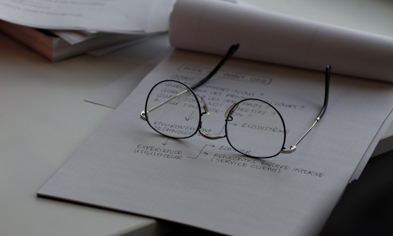 black framed eyeglasses on top of white printing paper