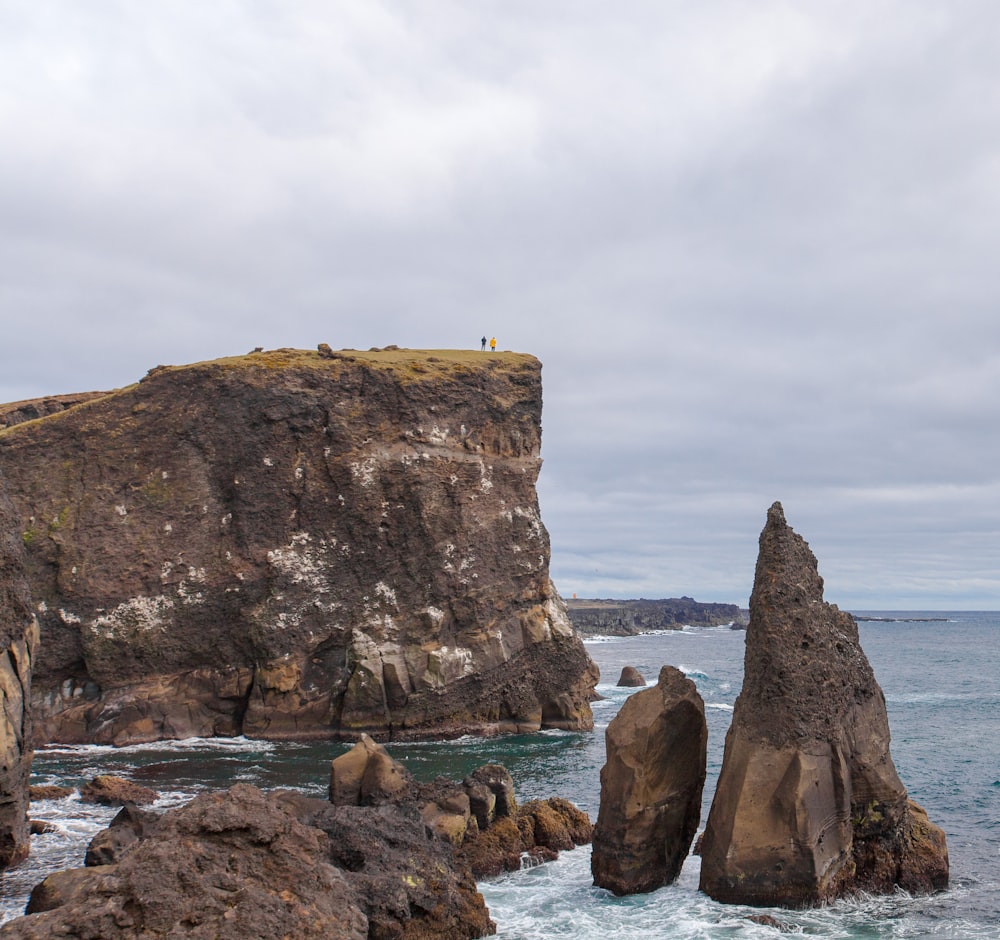 two person standing on cliff