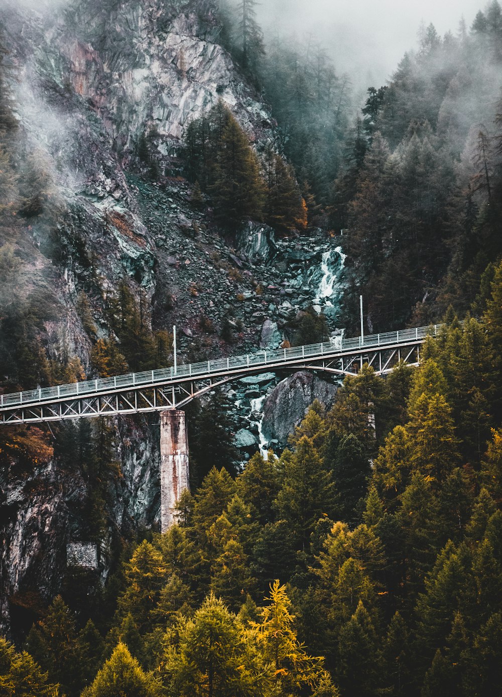 gray suspension bridge near rock formation