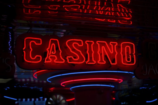 Neon lights display the word 'CASINO' in bright red, standing out against a dark background. The vibrant glow reflects a lively and bustling atmosphere.