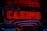 Neon lights display the word 'CASINO' in bright red, standing out against a dark background. The vibrant glow reflects a lively and bustling atmosphere.