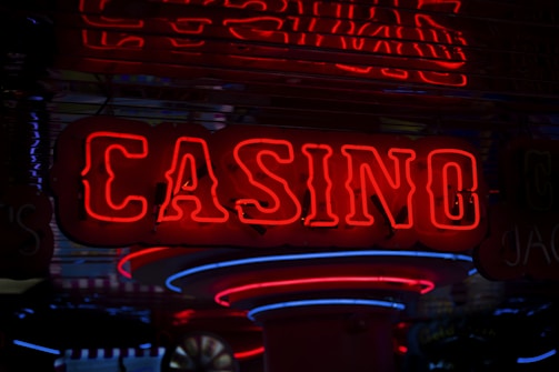 Neon lights display the word 'CASINO' in bright red, standing out against a dark background. The vibrant glow reflects a lively and bustling atmosphere.