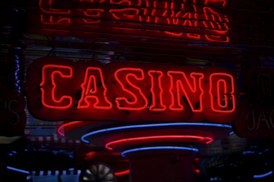 Neon lights display the word 'CASINO' in bright red, standing out against a dark background. The vibrant glow reflects a lively and bustling atmosphere.
