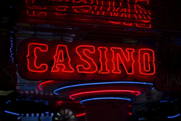 Neon lights display the word 'CASINO' in bright red, standing out against a dark background. The vibrant glow reflects a lively and bustling atmosphere.