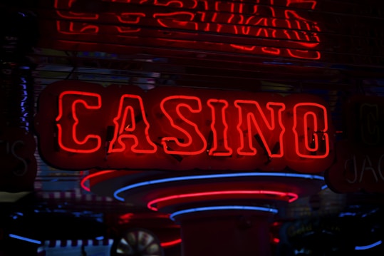 Neon lights display the word 'CASINO' in bright red, standing out against a dark background. The vibrant glow reflects a lively and bustling atmosphere.