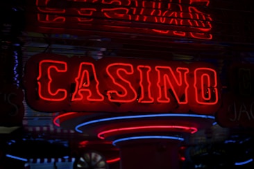 Neon lights display the word 'CASINO' in bright red, standing out against a dark background. The vibrant glow reflects a lively and bustling atmosphere.