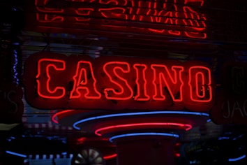 Neon lights display the word 'CASINO' in bright red, standing out against a dark background. The vibrant glow reflects a lively and bustling atmosphere.