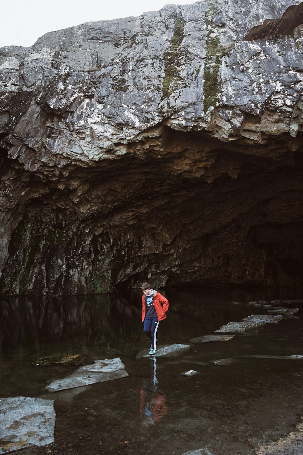 洞窟近くの石を踏む男