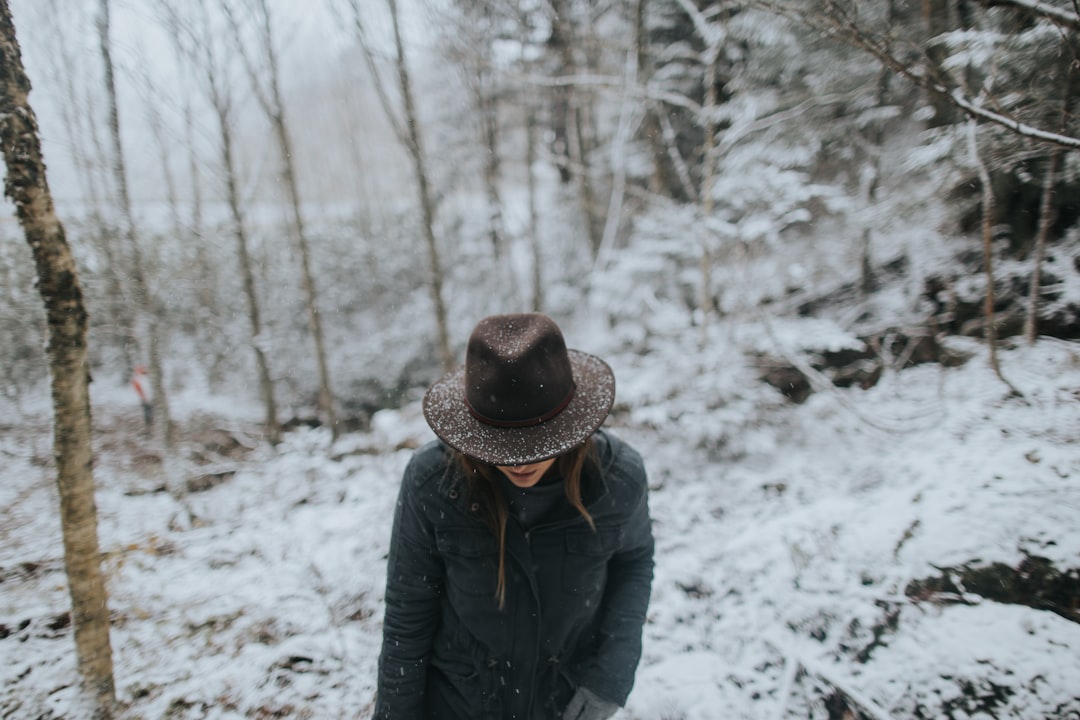 person wearing black coat and brown hat