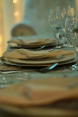 A close-up of a beautifully set dining table with plates and cutlery.