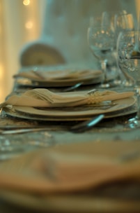 A close-up of a beautifully set dining table with plates and cutlery.