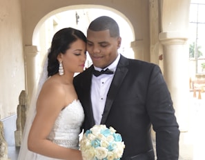 A couple exchanging vows under a beautifully decorated arch.