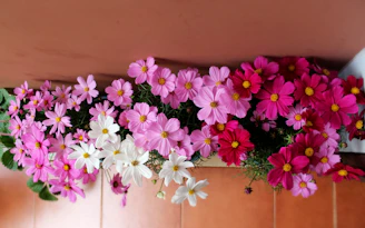 A vibrant birthday floral display featuring terracotta and soft sand hues, with children’s smiling faces blurred in the background.