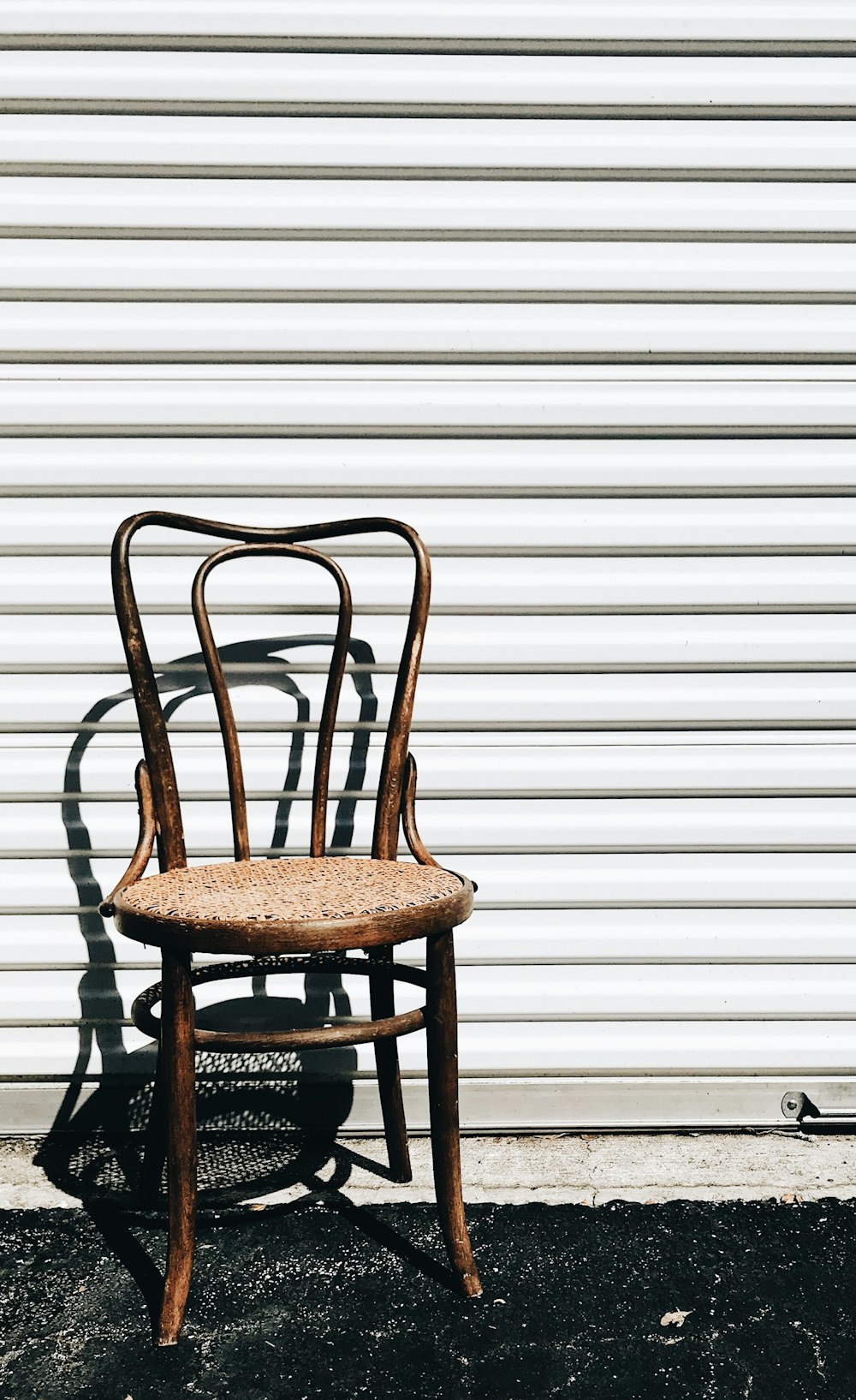 brown wooden chair beside white wall