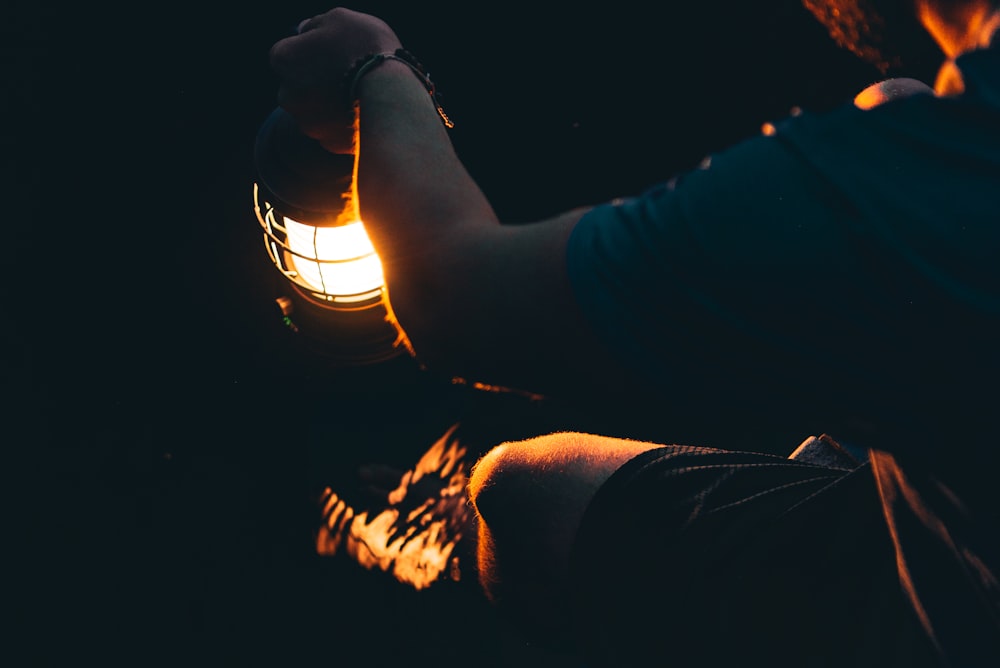 person holding lighted lantern during night time