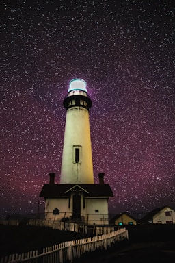 astrophotography,how to photograph spooky nights; white lighthouse under starry night