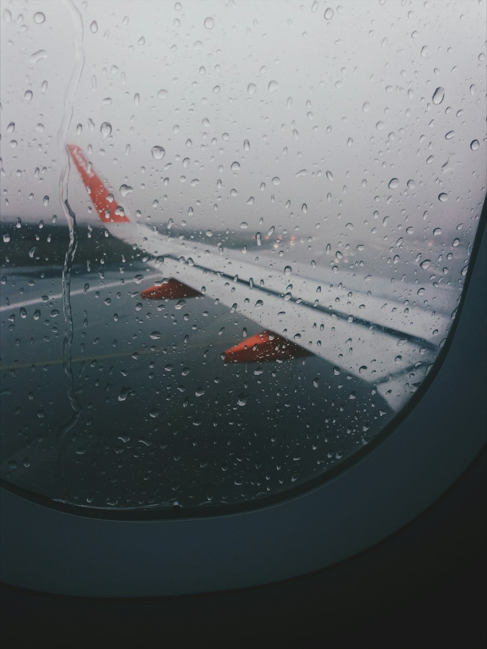 closeup photography of airplane window near body of water