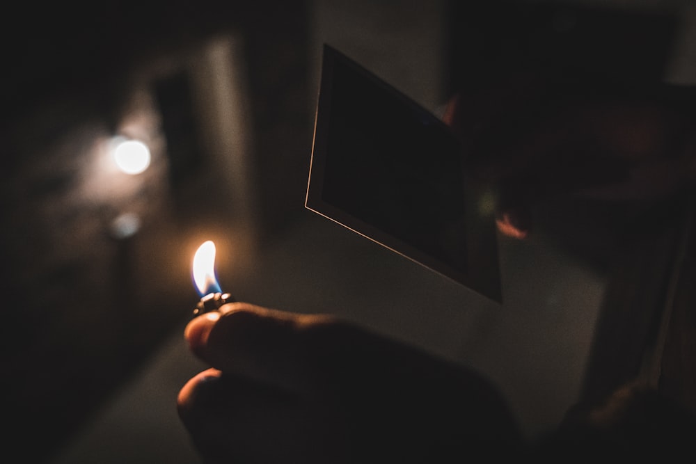 fotografia a fuoco superficiale di una persona che tiene in mano un accendino