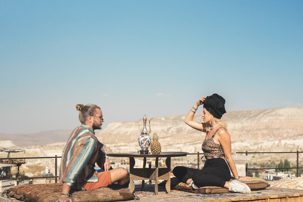 a man and a woman sitting on the ground