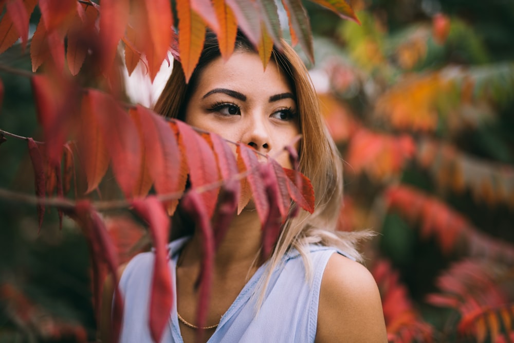 femme en haut blanc debout à l’extérieur entouré d’arbres