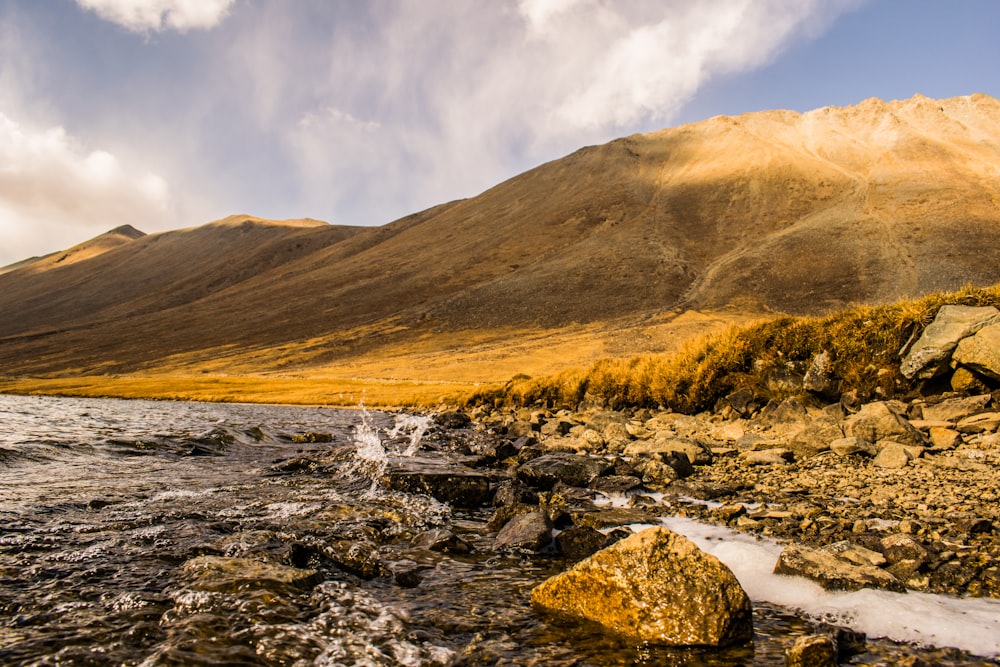 body of water with mountains during daytime