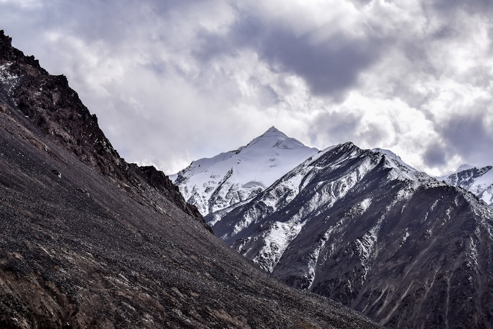 black mountain cover by snow under white clouds