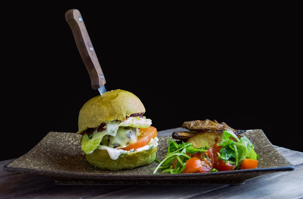 cooked burger on top of rectangular brown ceramic plate