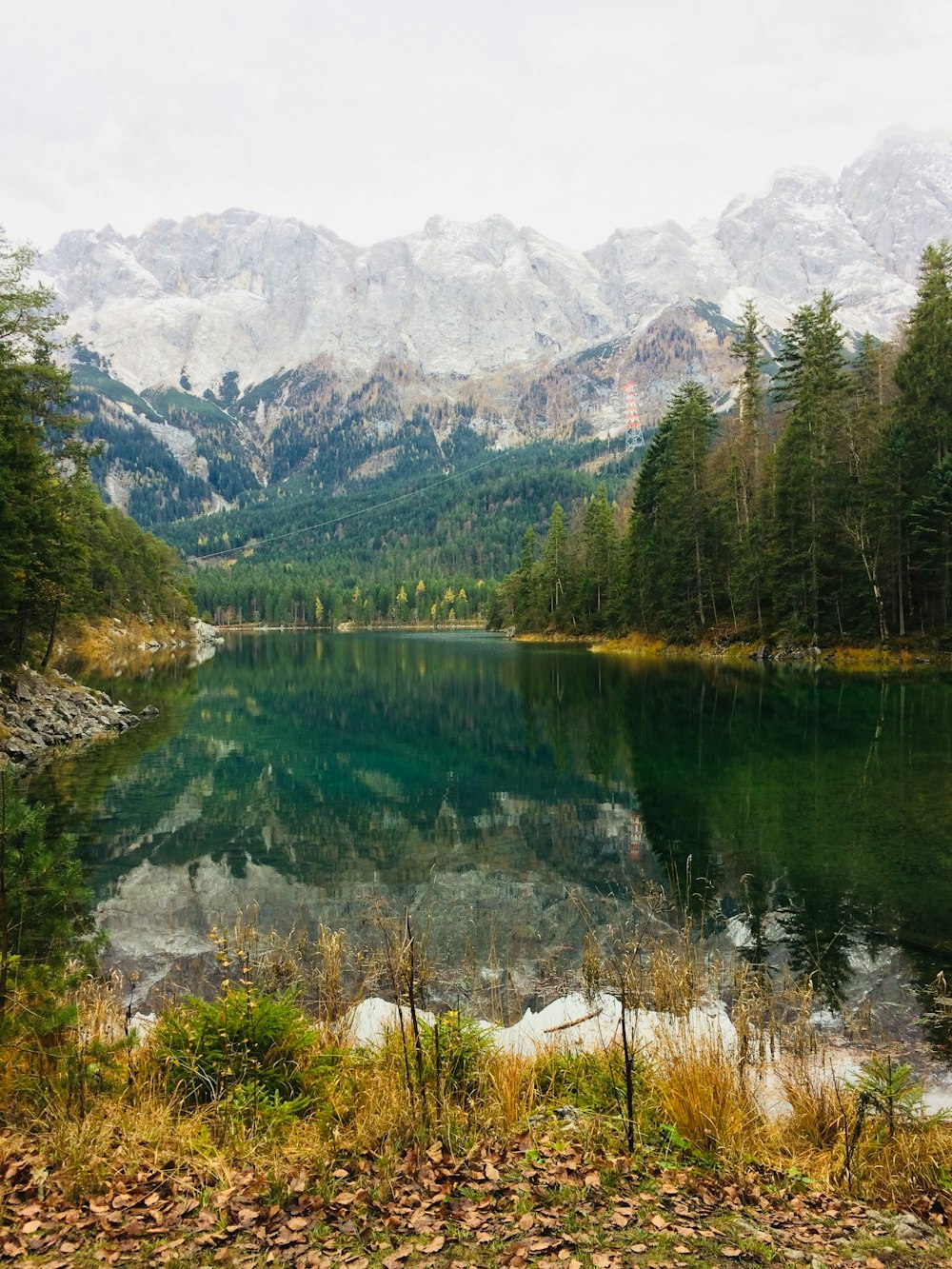 body of water surrounded by trees near mountain