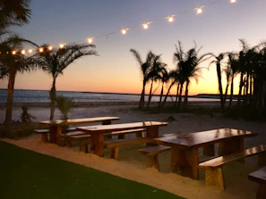 Sunset over a serene beach in Bali with a picnic spread of tropical fruits and healthy snacks.